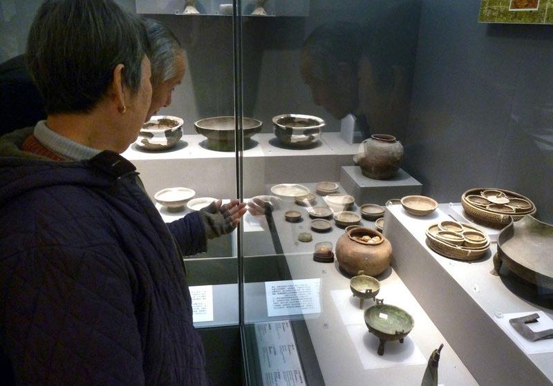 Des visiteurs regardent des œufs fossilisés datant de la Dynastie des Zhou de l'Ouest (1046-771 av. JC) au Musée de Nanjing à Nanjing, dans la Province du Jiangsu, dans l'Est de la Chine, le 13 décembre 2013. [Photo / icpress.cn]