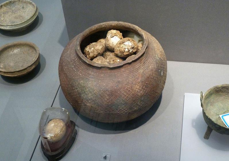 Un vieux pot contenant des œufs fossilisés couverts de poussière datant de la Dynastie des Zhou de l'Ouest (1046-771 av. JC) est exposé au Musée de Nanjing à Nanjing, dans la Province du Jiangsu, dans l'Est de la Chine, le 13 décembre 2013. Selon les archéologues, ces œufs sont les premiers de leur genre en Chine. [Photo / icpress.cn]