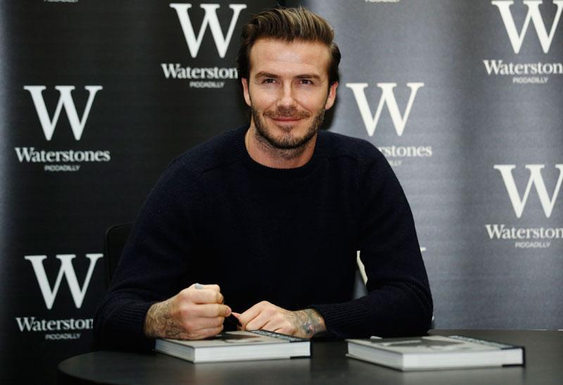 Le joueur de football à la retraite David Beckham pose avec son livre « David Beckham » dans une librairie à Londres le 19 décembre 2013. [Photo / agences]
