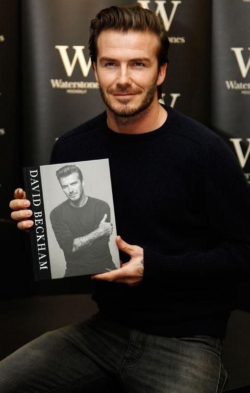 Le joueur de football à la retraite David Beckham pose avec son livre « David Beckham » dans une librairie à Londres le 19 décembre 2013. [Photo / agences]