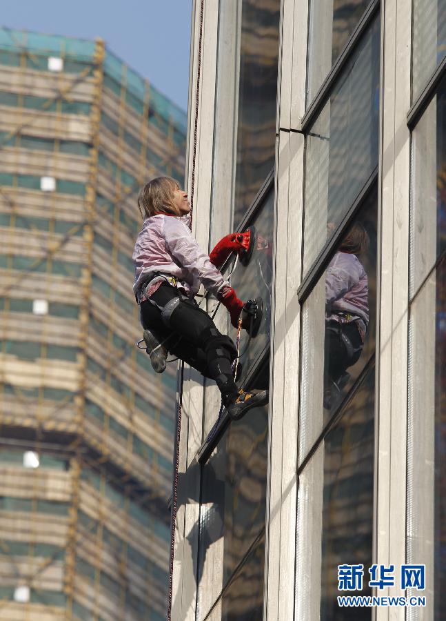Samedi 21 décembre 2013, Alain Robert, surnommé le Spiderman français, continue  de défier les lois de la gravité, en grimpant cette fois à mains nues le Centre Shimao Tianji, une structure d'une hauteur de 288 mètres à Shao Xing, dans la province du Zhejiang. Source : Xinhua (photo/ Liang Yongfeng)