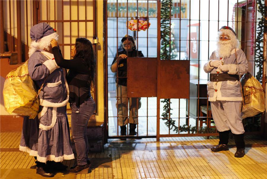 Des détenus habillés en Père Noël et Mère Noël se préparent à participer à une fête avant les fêtes de Noël à la prison pour femmes Santa Monica à Lima, le 20 décembre 2013. [Photo / agences]