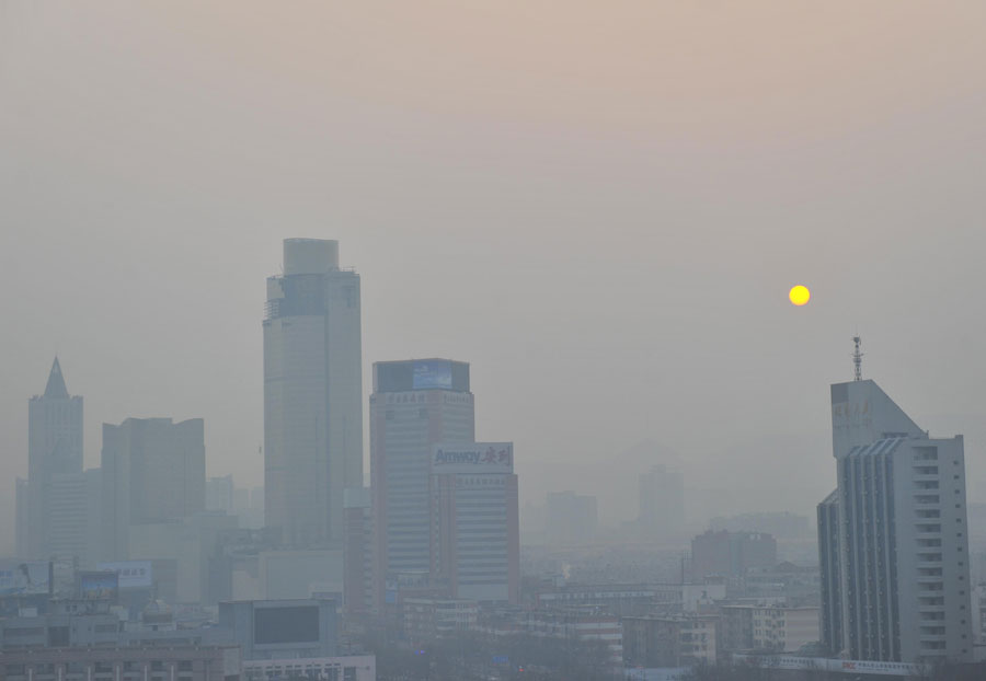 Le soleil se lève à travers un smog épais à Jinan, dans la province du Shandong, dans l'Est de la Chine, le 23 décembre 2013. [Photo Cui Pengsen / Asianewsphoto]