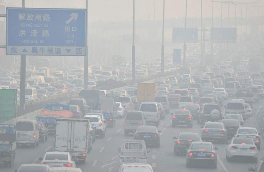 Des véhicules se déplacent sur une route pendant une période de fort smog dans la ville de Tianjin, en Chine du Nord, le 23 décembre 2013. [Photo / Xinhua]
