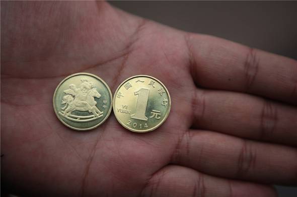 Deux nouvelles pièces d'un Yuan (0,16 Dollar US) destinées à commémorer l'Année lunaire chinoise du Cheval à Neijiang, dans la Province du Sichuan, le 24 décembre 2013. 