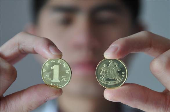 Deux nouvelles pièces d'un Yuan (0,16 Dollar US) destinées à commémorer l'Année lunaire chinoise du Cheval à Fuyang, dans la Province de l'Anhui, le 24 décembre 2013. La Banque populaire de Chine a émis mardi 100 millions de pièces d'un Yuan pour accueillir l'année du cheval. Les pièces d'un Yuan peuvent également être utilisées comme une monnaie ordinaire. 