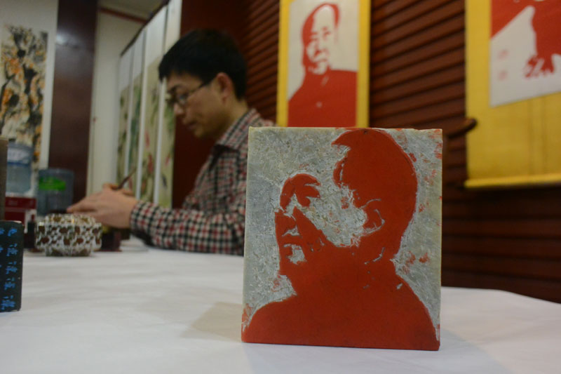Yang Jiangtao, de la ville de Zhengzhou, dans la province du Henan, en Chine centrale, a passé deux ans pour sculpter 120 badges et confectionner 120 papiers découpés du président Mao Zedong, pour commémorer le 120e anniversaire de la naissance de Mao. [Photo / Asianewsphoto]