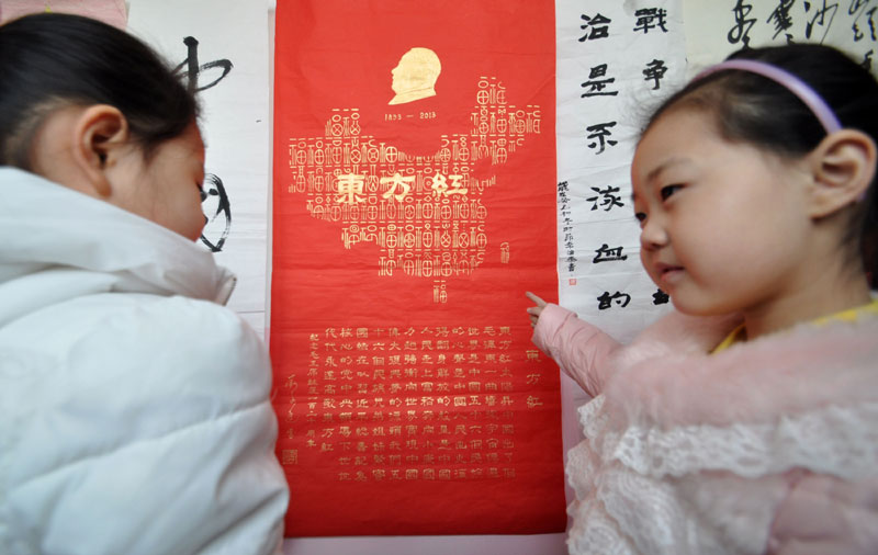 Des enfants lisent un poème écrit par le président Mao Zedong dans une exposition organisée à Handan, dans la province, du Hebei en Chine du Nord, pour commémorer le 120e anniversaire de la naissance de Mao, le 19 décembre 2013. [Photo / Asianewsphoto]