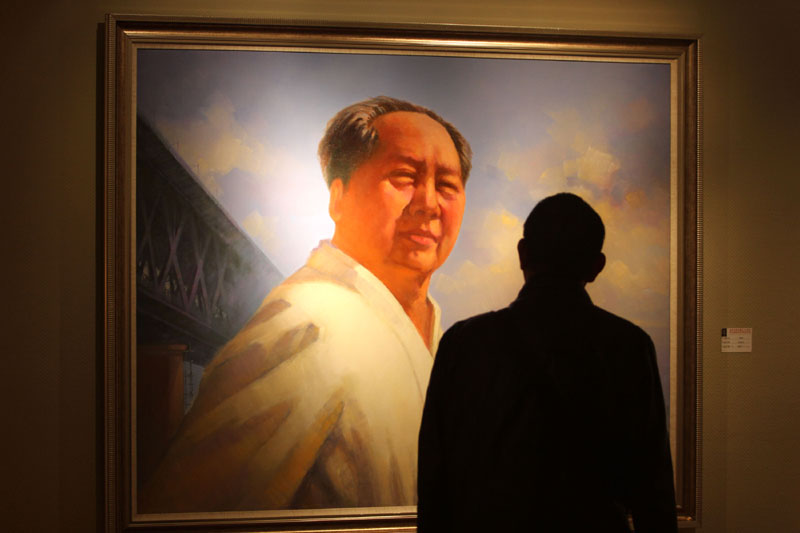 Un visiteur regarde une peinture à l'huile de Mao Zedong dans une exposition organisée dans la ville de Wuhan, en Chine centrale, pour commémorer le 120e anniversaire de la naissance de Mao, le 8 décembre 2013. [Photo / Asianewsphoto]