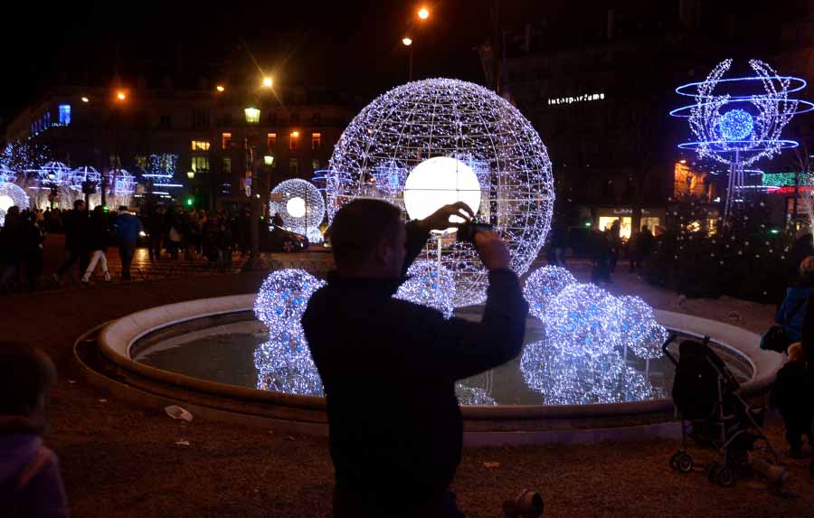 Le 23 décembre, un homme prend des photos des illuminations nocturnes sur les Champs-Elysées.
