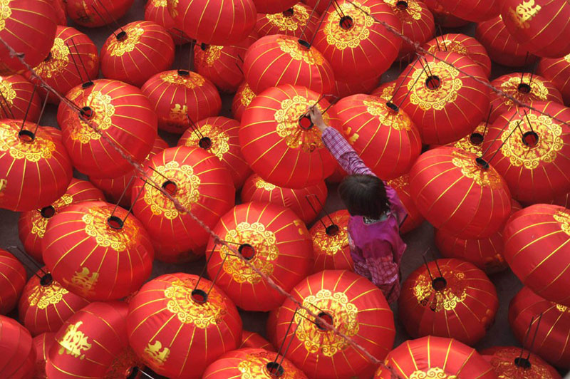 Une ouvrière du Comté de Jishan, dans la Province du Shanxi, prépare des lanternes rouges pour la Fête du Printemps, le mois prochain. Avec les vacances qui approchent, les usines de lanternes font monter leur production en puissance. Gao Xinsheng / China Daily