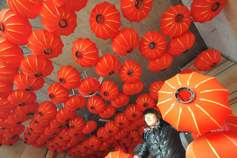 Une ouvrière du Comté de Jishan, dans la Province du Shanxi, prépare des lanternes rouges pour la Fête du Printemps, le mois prochain. Avec les vacances qui approchent, les usines de lanternes font monter leur production en puissance. Gao Xinsheng / China Daily