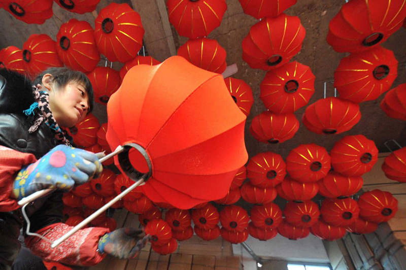 Une ouvrière du Comté de Jishan, dans la Province du Shanxi, prépare des lanternes rouges pour la Fête du Printemps, le mois prochain. Avec les vacances qui approchent, les usines de lanternes font monter leur production en puissance. Gao Xinsheng / China Daily