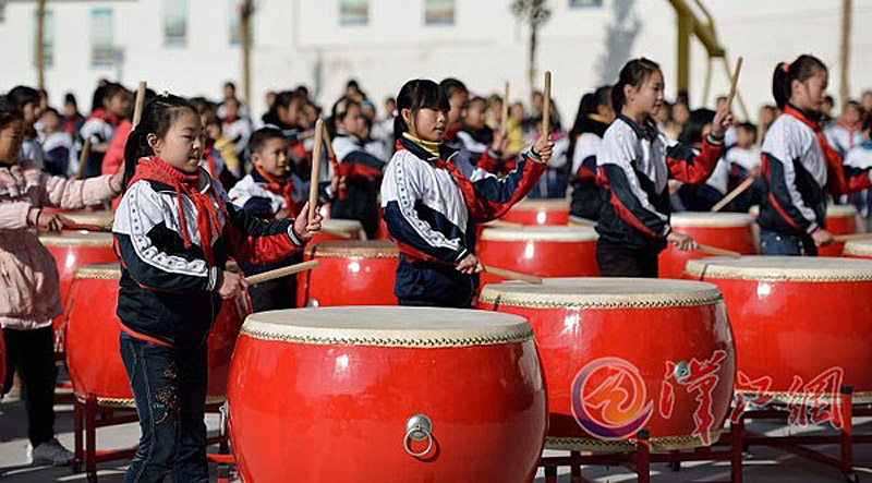 Des étudiantes jouent du gros tambour traditionnel sur le campus