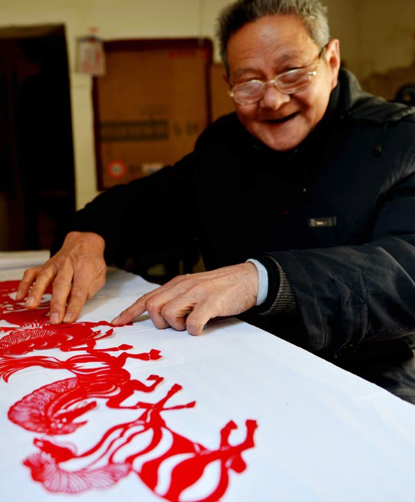 Chen Longyong montre son travail de découpage de papier, le 29 décembre 2013. L'artiste né dans les années 70 est natif de Yancheng, la province du Jiangsu, passionné par cet art depuis plus de 40 ans. Récemment, il a créé plusieurs œuvres sur le thème des chevaux, pour accueillir la nouvelle année, soit l'année du cheval selon le calendrier du zodiaque chinois. [Photo/Xinhua]