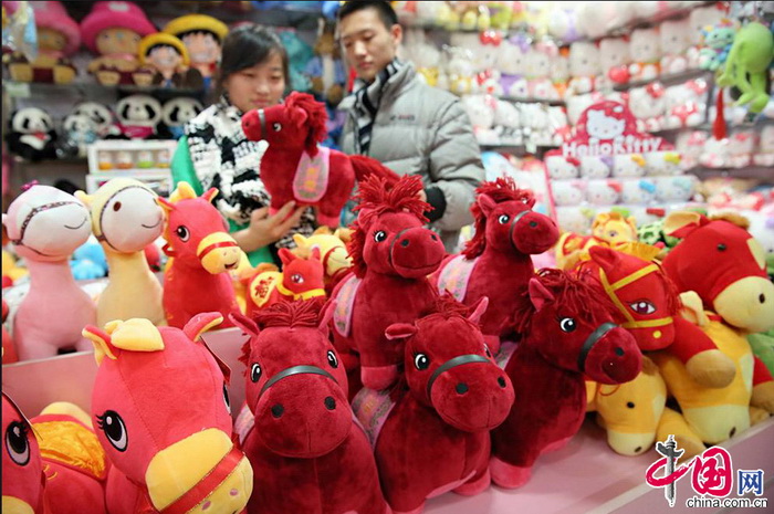 Le 29 décembre 2013, des clients achètent des peluches en forme de cheval dans un centre commercial de Beijing. 