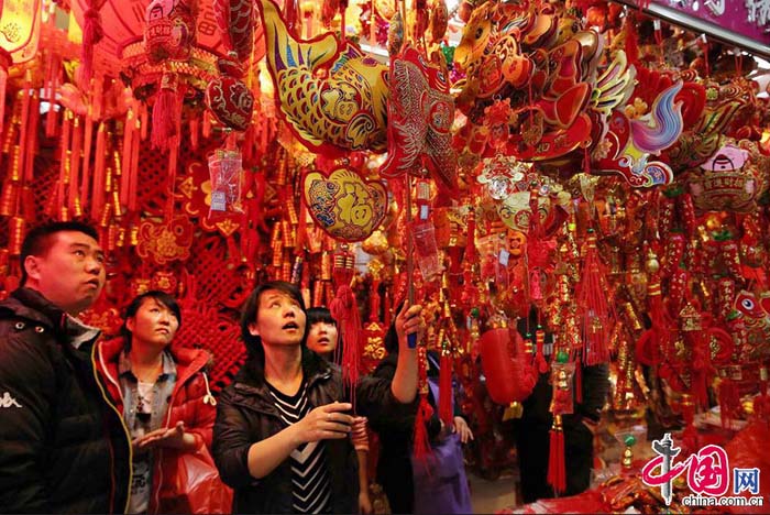 Le 29 décembre 2013, un vendeur décroche des ornements du Nouvel An chinois dans un centre commercial à Beijing. 