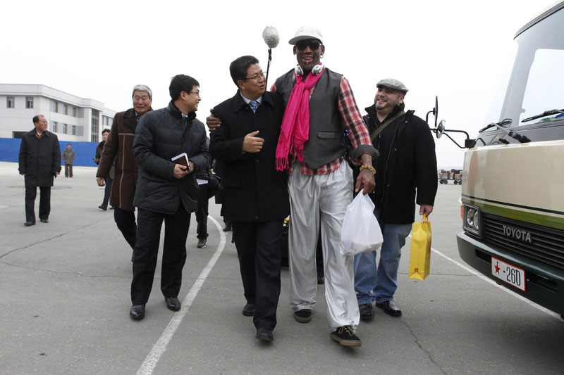 L'ancienne star de la NBA de basket Dennis Rodman, deuxième à droite, marche avec le vice-ministre du Ministère des Sports de la Corée du Nord Son Kwang Ho, troisième à droite, à son arrivée à l'aéroport international de Pyongyang, en Corée du Nord, lundi 6 janvier 2014.