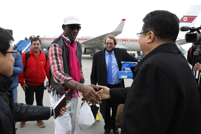 L'ancienne star de basket de la NBA Dennis Rodman serre la main du vice-ministre du Ministère des Sports de la Corée du Nord Son Kwang Ho à son arrivée à l'aéroport international de Pyongyang, en Corée du Nord, lundi 6 janvier 2014.