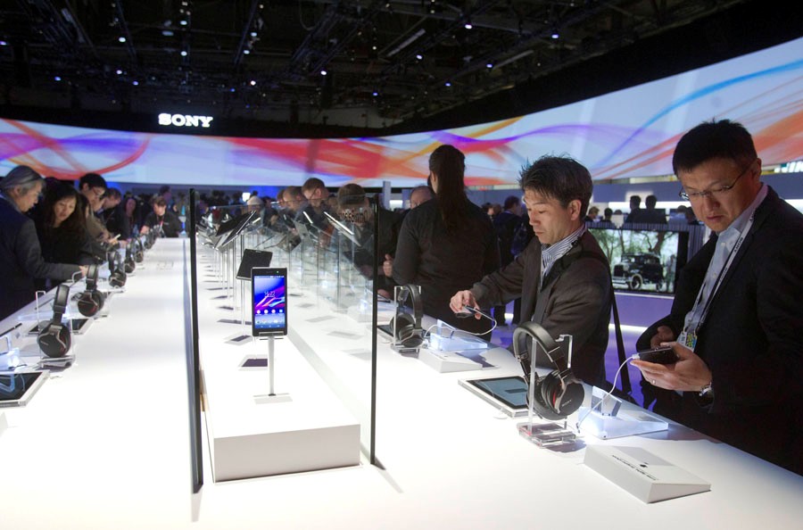 Des visiteurs regardent des casques et des smartphones Xperia Z1 sur le stand Sony lors de l'International Consumer Electronics Show (CES) 2014