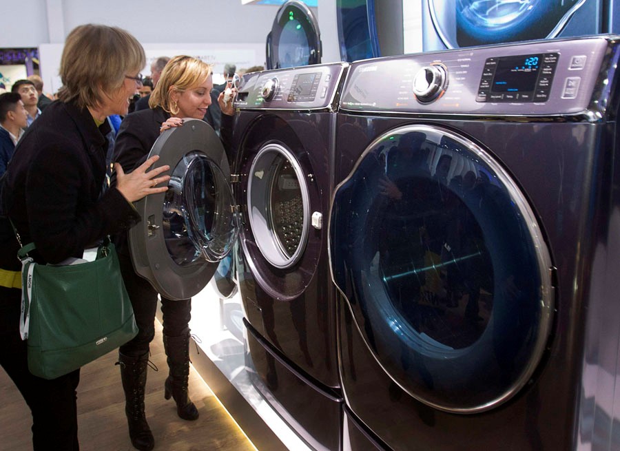 Kate Bulkley (à gauche) et Susan Brazer regardent un lave-linge et un sèche-linge de la série 9000 de Samsung Electronics lors de l'International Consumer Electronics Show (CES) 2014. Selon Samsung, ces deux appareils sont les plus grands du monde dans leur genre.