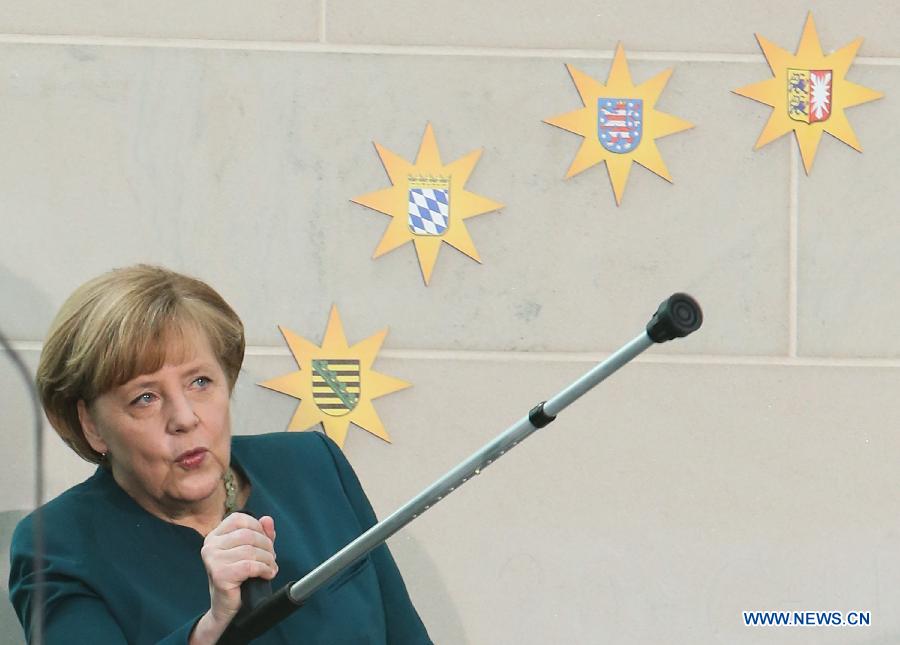 La chancelière allemande Angela Merkel pose avec des béquilles lors d'un événement caritatif, à la chancellerie, à Berlin, capitale allemande, le 7 janvier 2014. Merkel s'est blessée au bassin lorsqu'elle faisant du ski en Suisse au cours des vacances de Noël. 