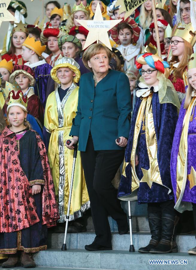 La chancelière allemande Angela Merkel pose avec des béquilles lors d'un événement caritatif, à la chancellerie, à Berlin, capitale allemande, le 7 janvier 2014. Merkel s'est blessée au bassin lorsqu'elle faisant du ski en Suisse au cours des vacances de Noël. 