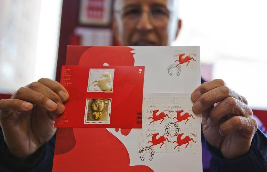 Armando Rodriguez, collectionneur de timbres, montre sa collection de l'Année du Cheval dans un bureau de poste à Toronto, le 13 janvier 2014. [Photo / Xinhua]
