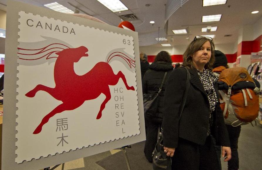 Une affiche de promotion des timbres de l'Année du Cheval exposée dans un bureau de poste à Toronto, le 13 janvier 2014. [Photo / Xinhua]
