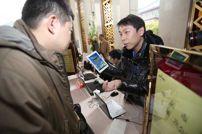 Un conseiller politique apprend à utiliser une tablette numérique après son inscription à la session plénière du comité de Nanjing de la Conférence consultative politique du peuple chinois (CCPPC), dans la capitale de la province du Jiangsu, le 11 janvier 2014.