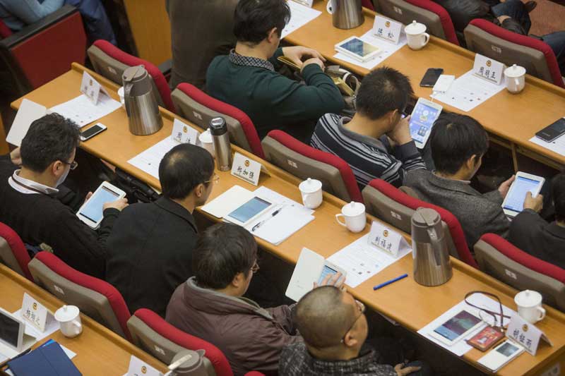 Les conseillers politiques ont pu utilisé des tablettes numériques pour télécharger des documents et présenter des propositions le 11 janvier 2014, lors d'une session plénière du comité de Nanjing de la Conférence consultative politique du peuple chinois (CCPPC), dans la capitale de la province du Jiangsu. Cette évolution devrait permettre d'économiser environ 1,5 million de de yuans (248 000 $) au cours des quatre prochaines années en réduisant l'utilisation et la distribution de matériel imprimé. [Photo: Song Qiao/Asianewsphoto]