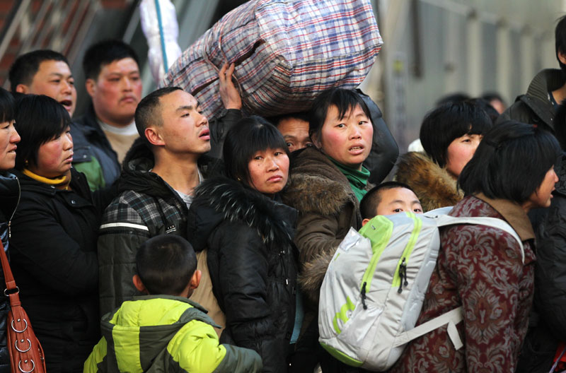 Des passagers attendent pour embarquer à bord d'un train à la gare de l'Ouest de Beijing mardi avant le pic annuel des voyages de la Fête du Printemps de 40 jours, qui commence jeudi. [Photo Zou Hong / China Daily]