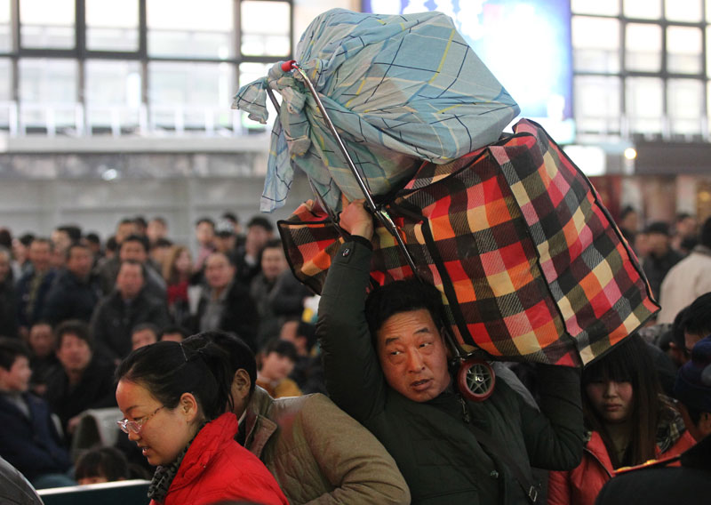 Des passagers attendent pour embarquer à bord d'un train à la gare de l'Ouest de Beijing mardi avant le pic annuel des voyages de la Fête du Printemps de 40 jours, qui commence jeudi. [Photo Zou Hong / China Daily]