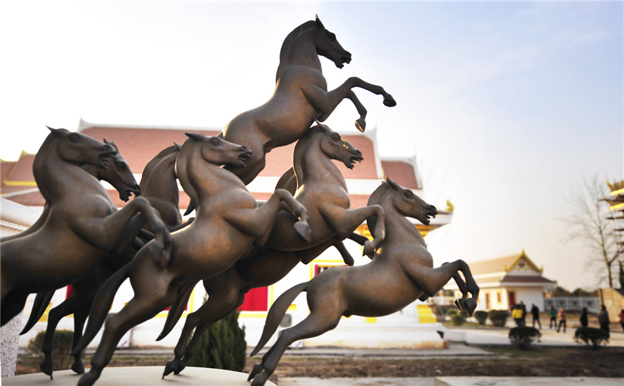 Des statues de chevaux devant la zone de temple bouddhiste de style thaïlandais dans le temple du Cheval Blanc, ou Bai Ma Si, à Luoyang, dans la province du Henan, au centre de la Chine, le 12 janvier 2014. [Photo / Asianewsphoto ]