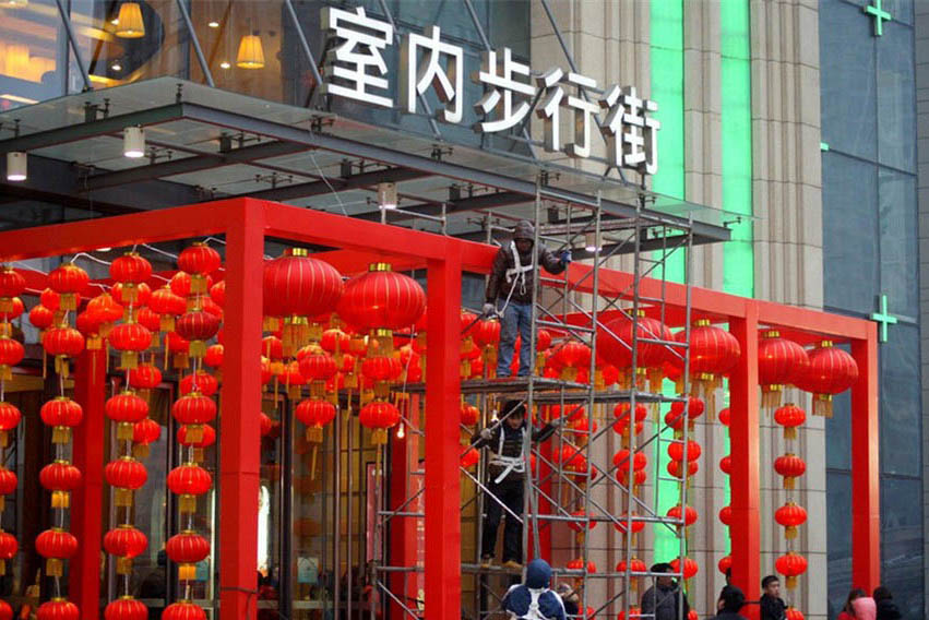 Un centre commercial dans le centre-ville de la ville de Jinan, dans la Province du Shandong, dans l'Est de la Chine, décore son entrée avec des lanternes rouges, le 17 janvier 2014. [photo / icpress.cn]
