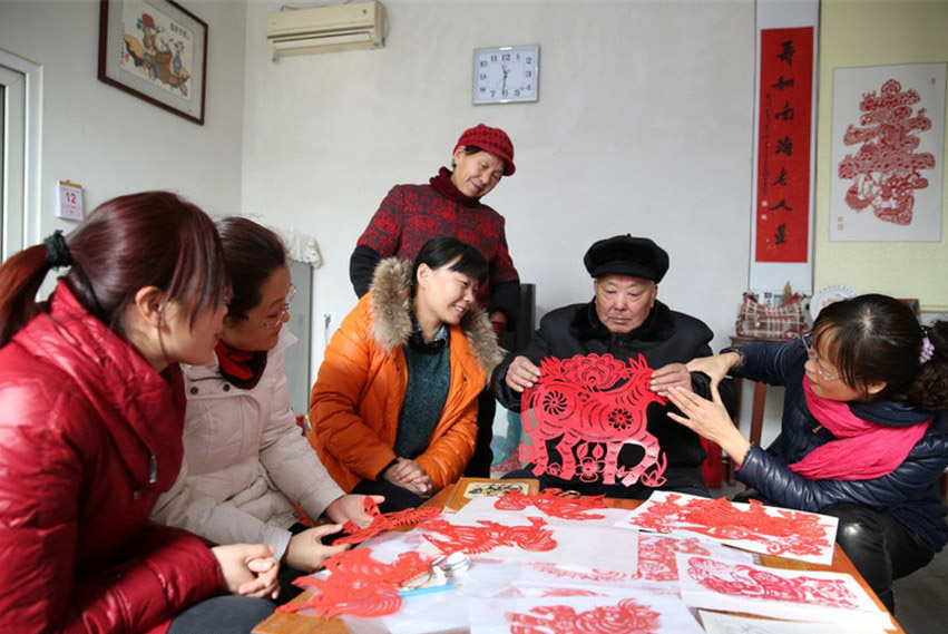 Yu Yongsheng, un maître du papier découpé du Comté de Lüxian, dans la ville de Rizhao, dans la Province du Shandong dans l'Est de la Chine montre ses œuvres chez lui, le 13 janvier 2014. [photo / icpress.cn]
