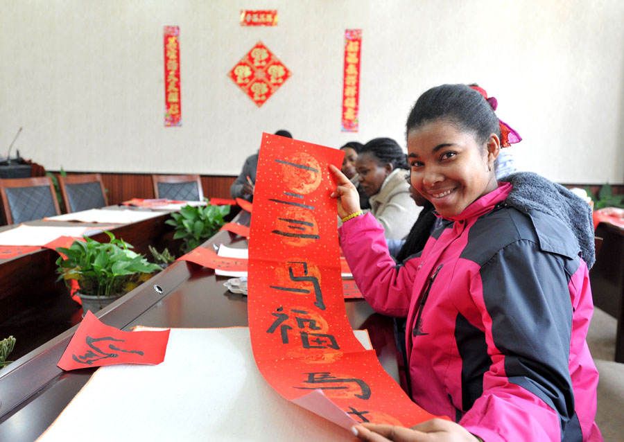 Une étudiante étrangère devant son couplet, écrit à Nanjing, la province du Jiangsu en Chine orientale, le 20 janvier 2014.
