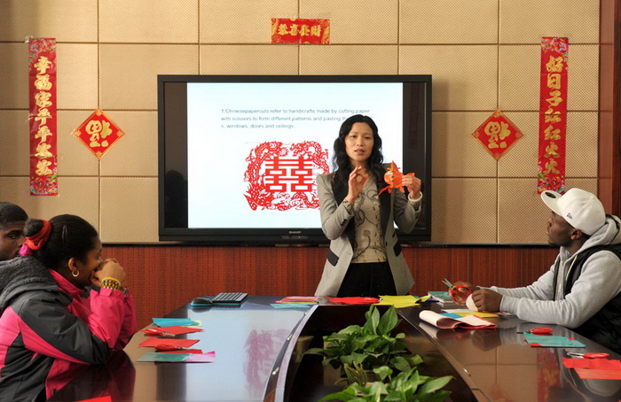 Des élèves apprennent l'art du papier découpé, lors d'une session d'échange culturel à Nanjing, la province du Jiangsu en Chine orientale, le 20 janvier 2014.