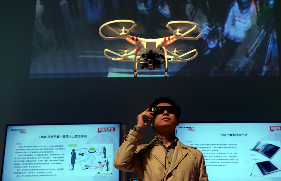 Un développeur porte une paire de lunettes numériques, ou un récepteur portable, pour surveiller la vidéo en direct transmis à partir d'un véhicule aérien sans pilote, lors de l'exposition de lenovo Innovation 2014 à la 798 Art Zone de Beijing, le 19 janvier 2014 [Photo/ chinadaily.com.cn] 