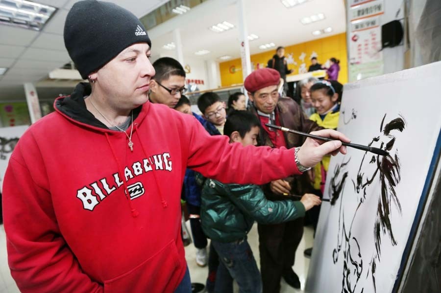 Jonathan, un Américain, a rencontré des artistes folkloristes et des enfants de la communauté de Haocheng pour exécuter une peinture sur le thème du cheval et certains travaux de calligraphie pour accueillir le prochain Nouvel An lunaire -l'Année du Cheval- à Nantong, dans la Province du Jiangsu, le 24 janvier. [Photo Xu Peiqin / Asianewsphoto]