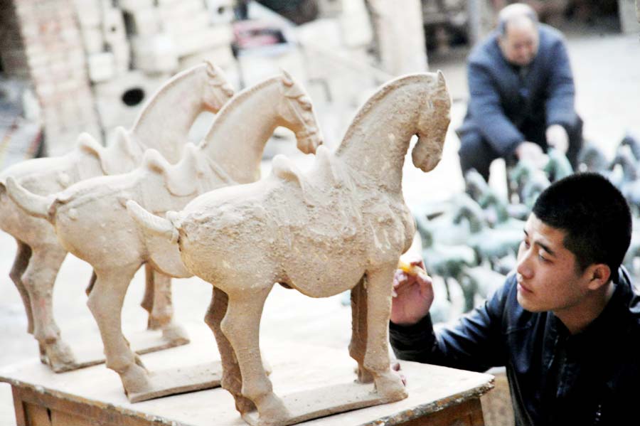 Wang Lancheng (à gauche) et son petit-fils Wang Feng travaillent sur des répliques de chevaux en poterie du style des dynasties Han et Tang à Yuncheng, dans la province du Shandong.