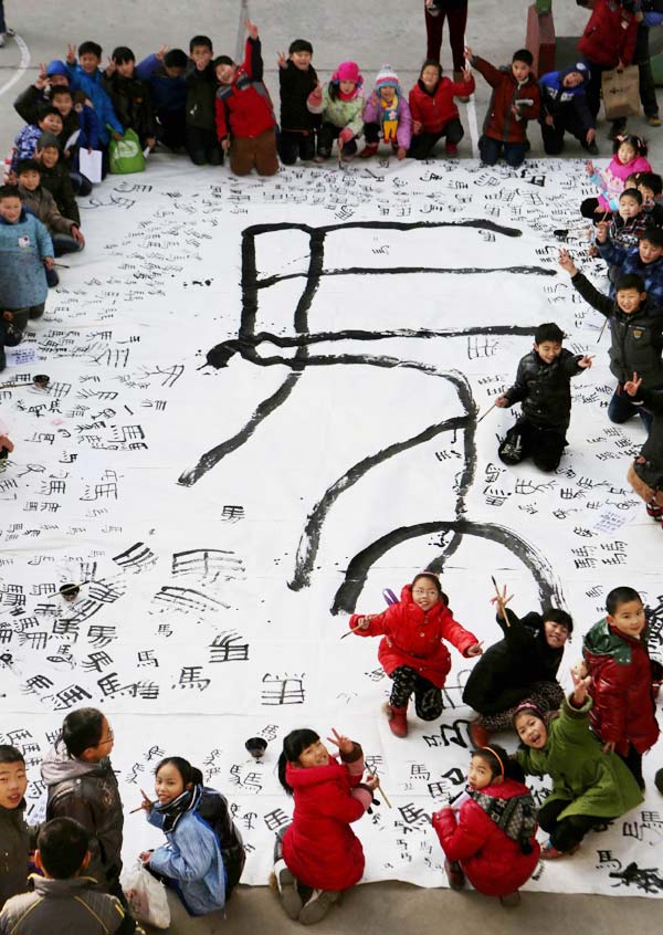 Des enfants de Ma'anshan, dans la province de l'Anhui, montrent leur oeuvre de calligraphie, ils l'ont créée avec leur professeur en utilisant différents styles du caractère chinois « cheval ».