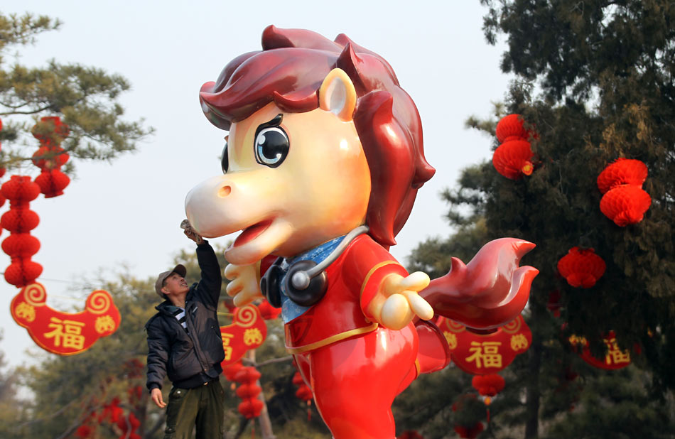 Un homme nettoie une statue de cheval au Parc Ditan, à Beijing, le 27 janvier 2014. [Photo Zou Hong / Asianewsphoto]