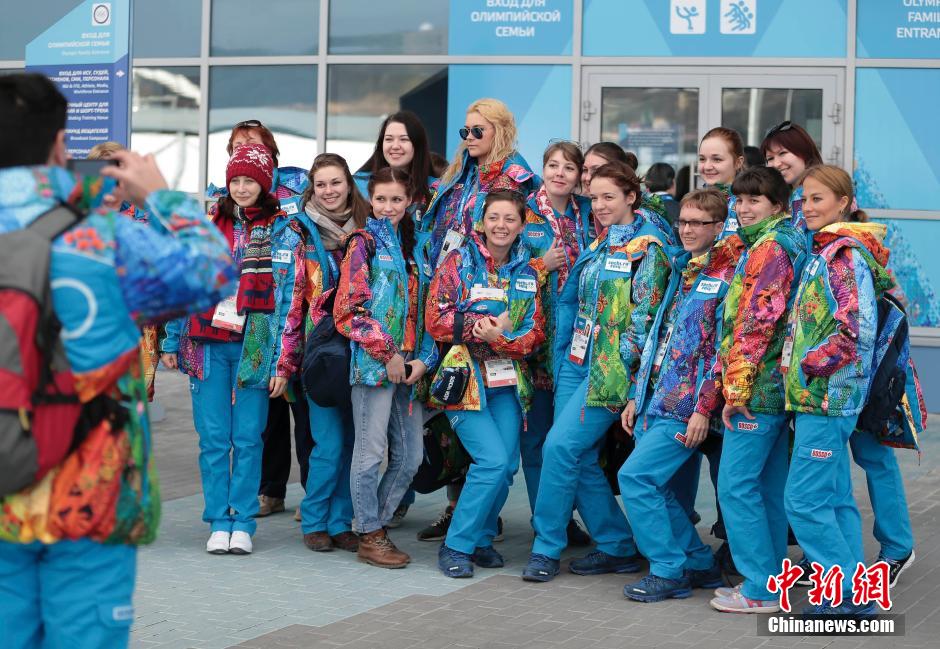 Le 6 février 2014, plusieurs volontaires des JO d'hiver de Sotchi se font photographier devant un des sites olympiques.