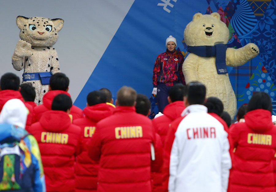 Les membres de l'équipe olympique de la Chine regardent les mascottes des Jeux olympiques lors d'une cérémonie de bienvenue organisée pour l'équipe dans le village des athlètes au Parc olympique, avant les Jeux olympiques d'hiver 2014 de Sotchi, le 5 février 2014. [Photo / agences]