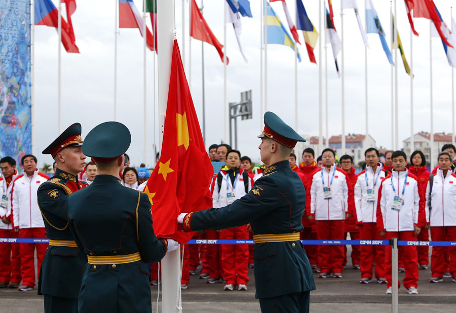 Des soldats russes hissent le drapeau national chinois au cours d'une cérémonie de bienvenue organisée pour l'équipe dans le village des athlètes au Parc olympique, avant les Jeux olympiques d'hiver 2014 de Sotchi, le 5 février 2014. [Photo / agences]