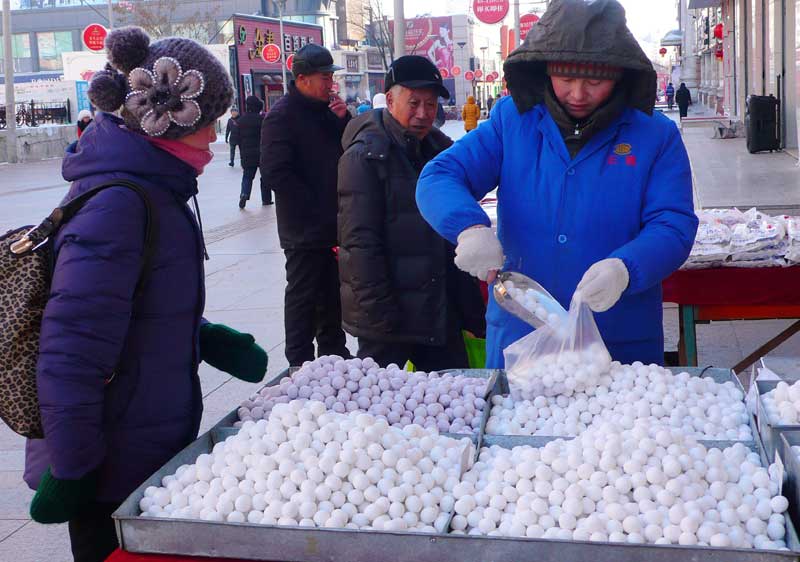 Une femme achète différentes yuanxiao (petites boulettes de pâte de riz), le 7 février à Heihe, dans la province chinoise du Heilongjiang. (Photo : Qiu Qilong/Asianewsphoto)