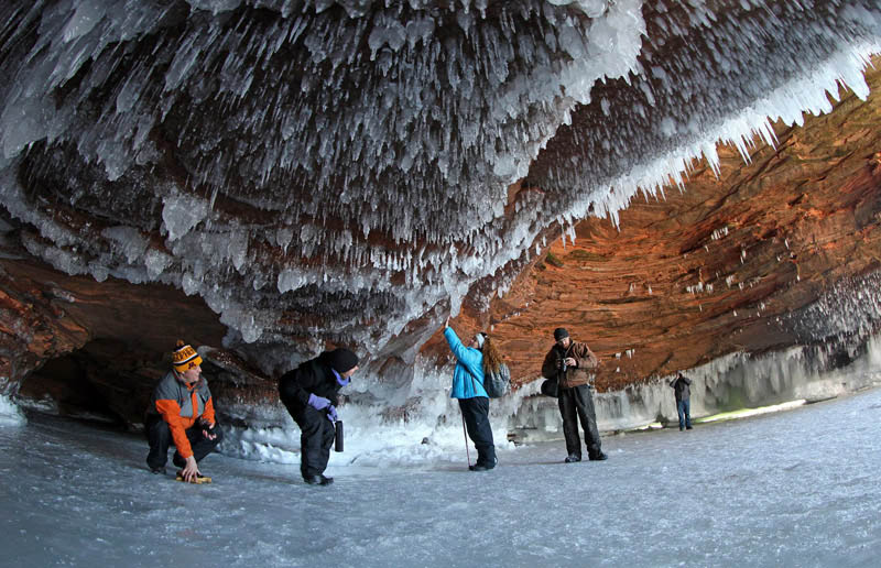 Des touristes s'accroupissent pour éviter les glaçons dans une grotte sous-marine sur le Lac Supérieur gelé, le plus grand lac d'eau douce du monde, à l'Apostle Islands National Lakeshore près de Cornucopia, dans le Wisconsin, le 14 février 14 2014. [Photo/agences]
