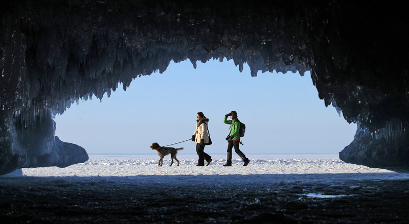 Des touristes entourés de glaçons d'une grotte aquatique alors qu'ils se déplacent à travers une étendue gelée du Lac Supérieur, le plus grand lac d'eau douce du monde, à l'Apostle Islands National Lakeshore près de Cornucopia, dans le Wisconsin, le 14 février 2014. [Photo/agences]