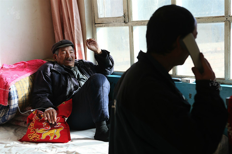 Li Zhanrong, 80 ans, reçoit un traitement de IV. Il a élevé un neveu, qui peut maintenant prendre prend soin de lui quand il est malade.